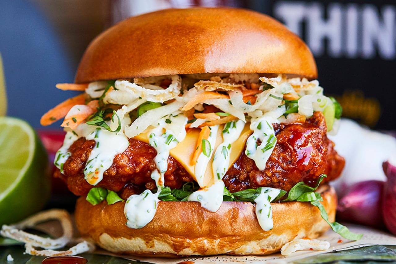 Fried chicken burger with sriracha, Thai slaw, cheese and ranch mayo