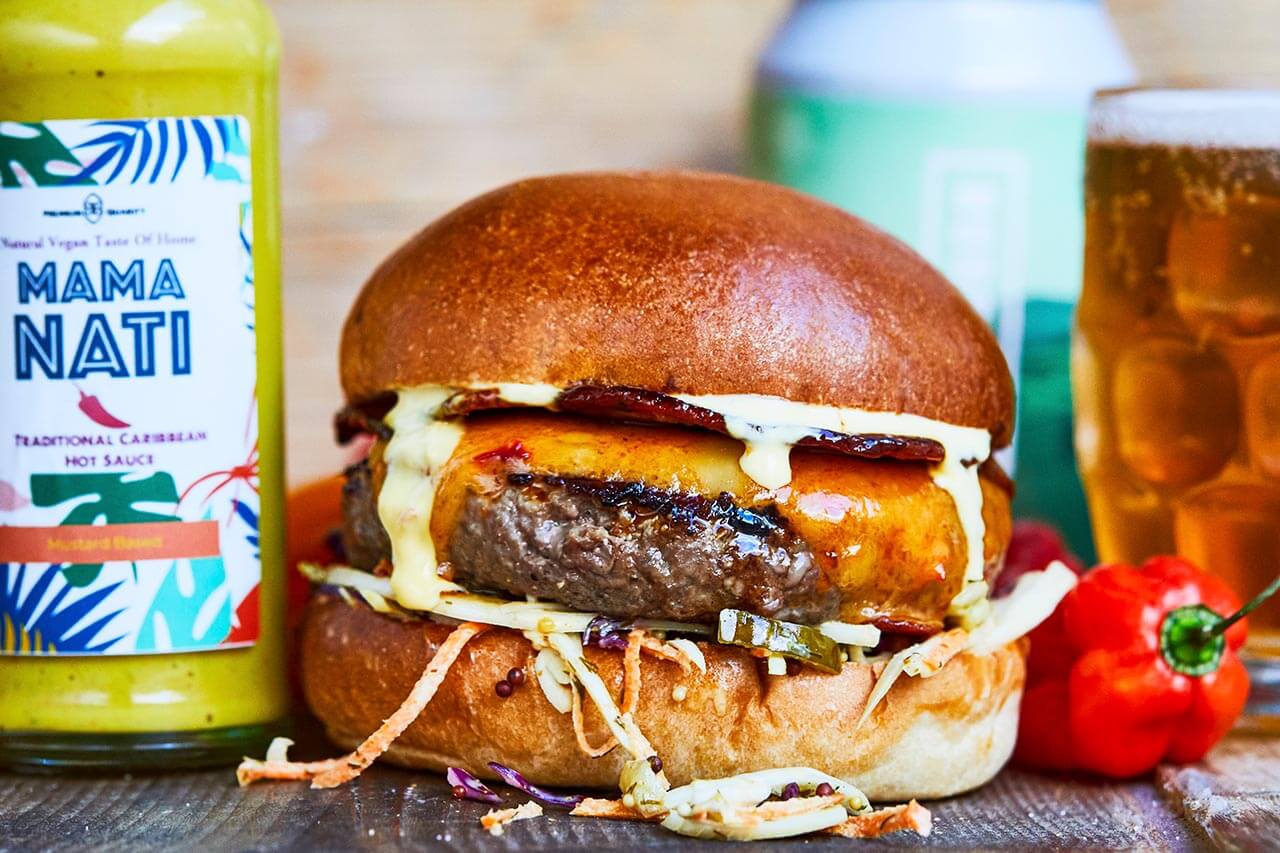 Beef burger with candied bacon, chilli cheese, mama nati hot sauce mayo and carribean slaw