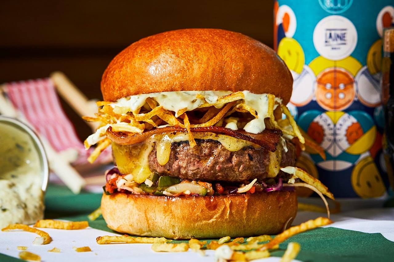 A new burger just for The Fortune of War on Brighton beach - beef, candied bacon, cheese, shoestring fries, garlic mayo and slaw with chips.jpg